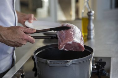 Das Fleisch aus der Pfanne nehmen.