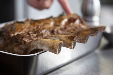 Die Kräuter und den Knoblauch aus dem Kalbfleisch entfernen.