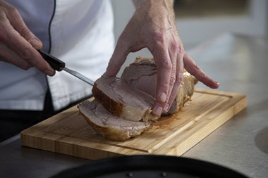 Das Kalbfleisch in Stücke schneiden.
